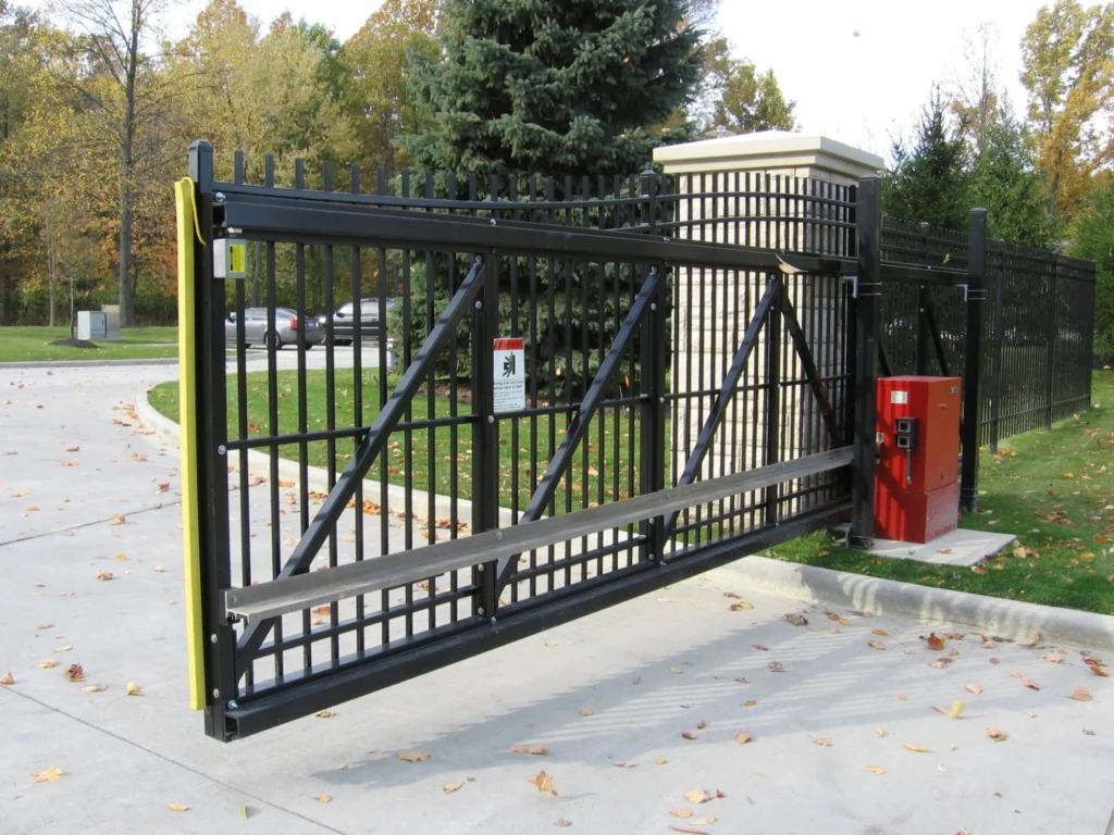 A metal sliding driveway gate with an automated opener and control system.
