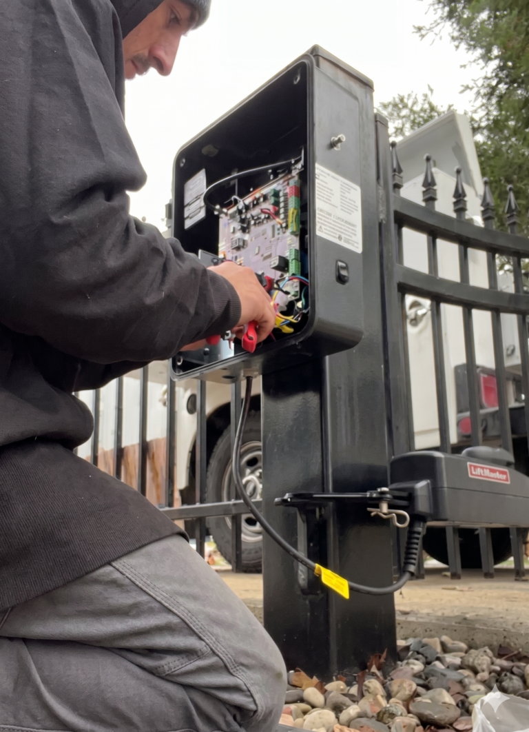 A technician repairs the wiring inside a panel because the automatic gate won't open.